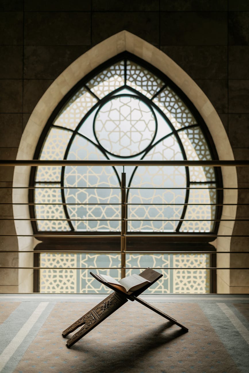 open koran on a holder by a mosque window